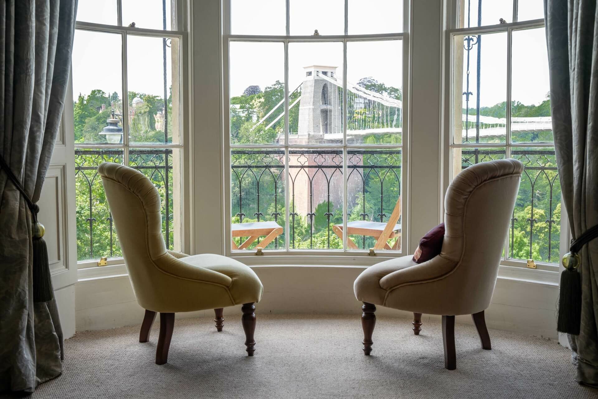 Two armchairs in front of finished double glazed sash windows overlooking Bristol Suspension Bridge by New Life Sash Window Co