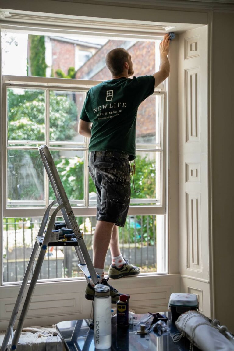 New Life Sash Window Co team member on a ladder installing brand new sash windows