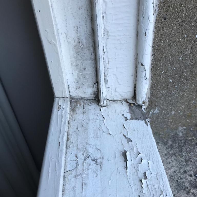 Close up of old, rotten window sill with paint peeling